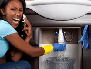 Emergency plumbing repair for a leaking sink drain under a bathroom vanity in Aurora, CO