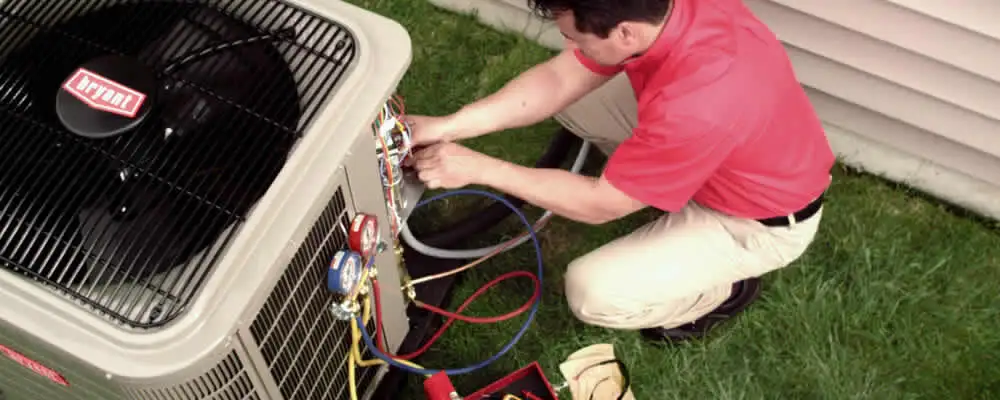 HVAC technician servicing an outdoor air conditioner unit in Aurora, CO