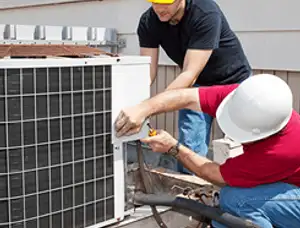 HVAC technicians repairing an outdoor AC unit on a rooftop in Aurora, CO