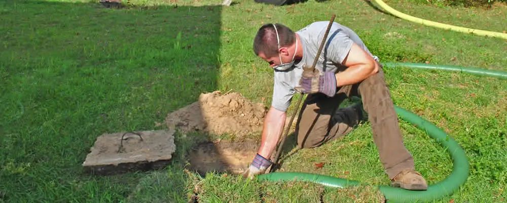 Septic pumping technician servicing a residential septic tank in Aurora, CO
